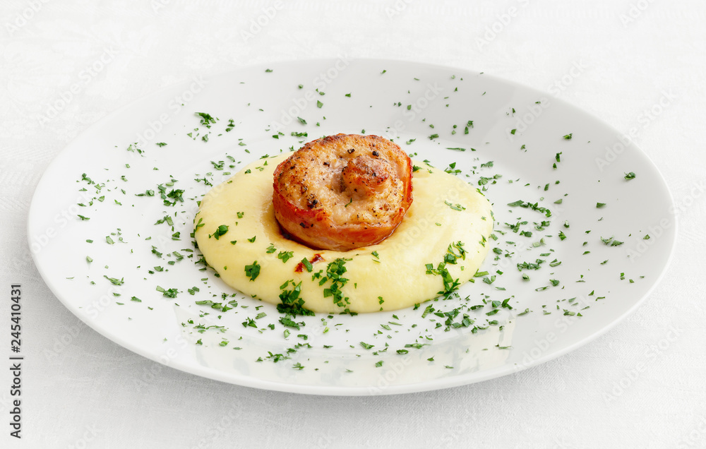 bacon wrapped spiralled rabbit loin on mashed potato decorated with parsley bacon wrapped spiralled rabbit loin on mashed potato decorated with parsley
