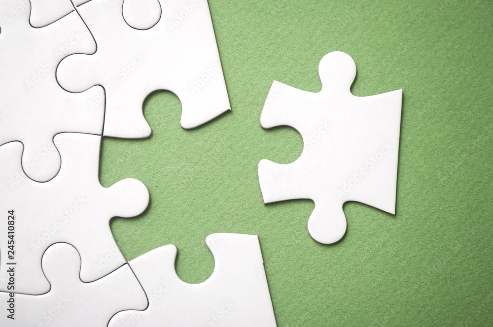 closeup of the last piece of jigsaw puzzle missing on green background to complete the mission closeup of the last piece of jigsaw puzzle missing on green background to complete the mission