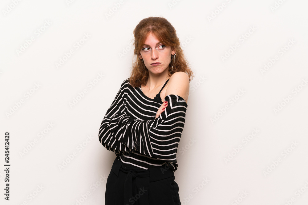 Young redhead woman over white wall making doubts gesture while lifting the shoulders Young redhead woman over white wall making doubts gesture while lifting the shoulders
