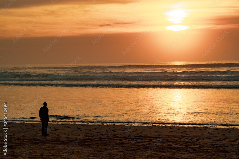 Sunset over main beach in Agadir Morocco showing silhouettes and reflections