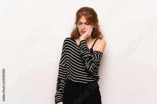 Young redhead woman over white wall with toothache