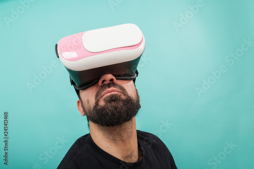 Bearded man use virtual reality glasses  goggles. Guy in VR headset is looking at interactive screen. Playing mobile game app on device.