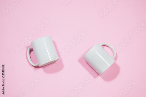 White coffe mugs on pink background 