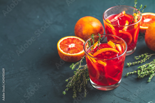 Red orange juice in a large glass or blood orange sparkling vodka cocktail or aperitif with campari photo