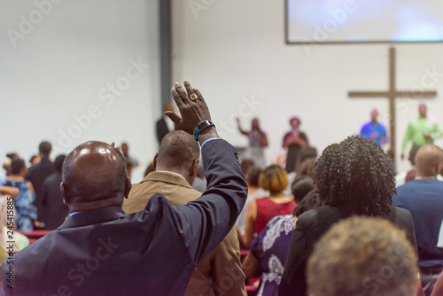 African American Man at Church with His Hand Raised photo