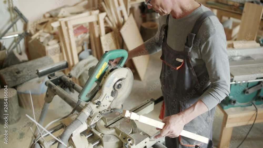 High angle view of skilled furniture maker working on table leg. Man making decorative cuts in piece of wood High angle view of skilled furniture maker working on table leg. Man making decorative cuts in piece of wood