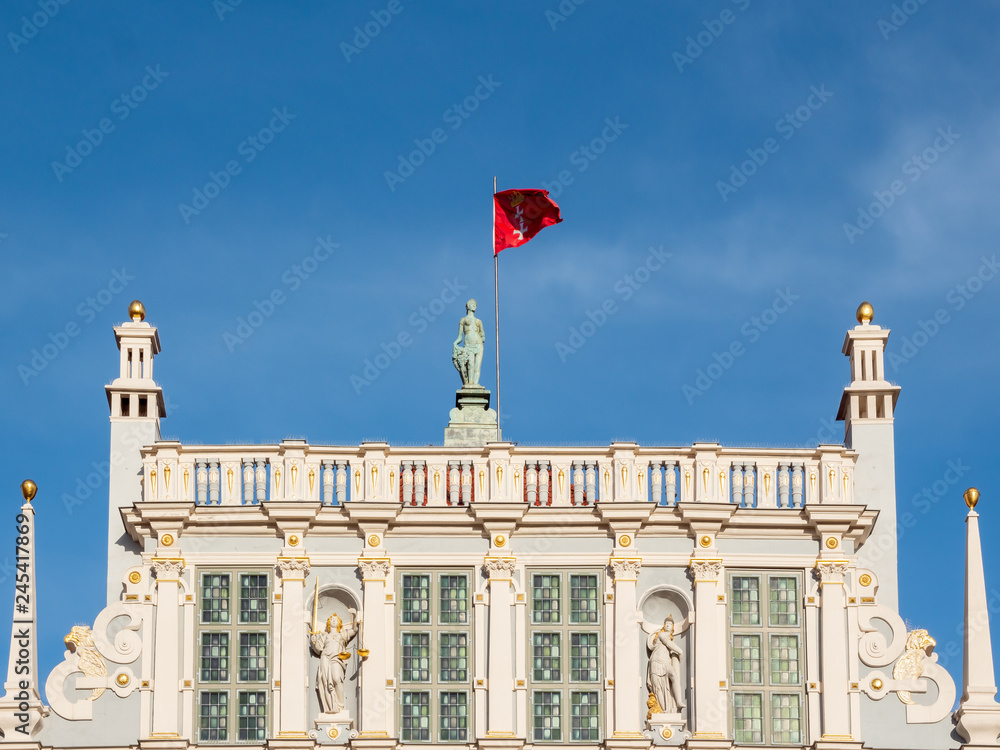 Gdansk, Poland, city flag, sign of Gdansk, on top of old building - Artus Court.