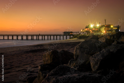 Pier on the Atlantic Ocean in Swakompund, Namibia. Beautiful sunset with a bright sky and soft gentle water and sand photo