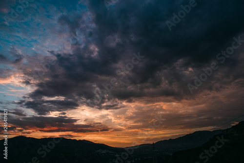 Dramatic purple and orange cloudy sunset with mountain silhouette