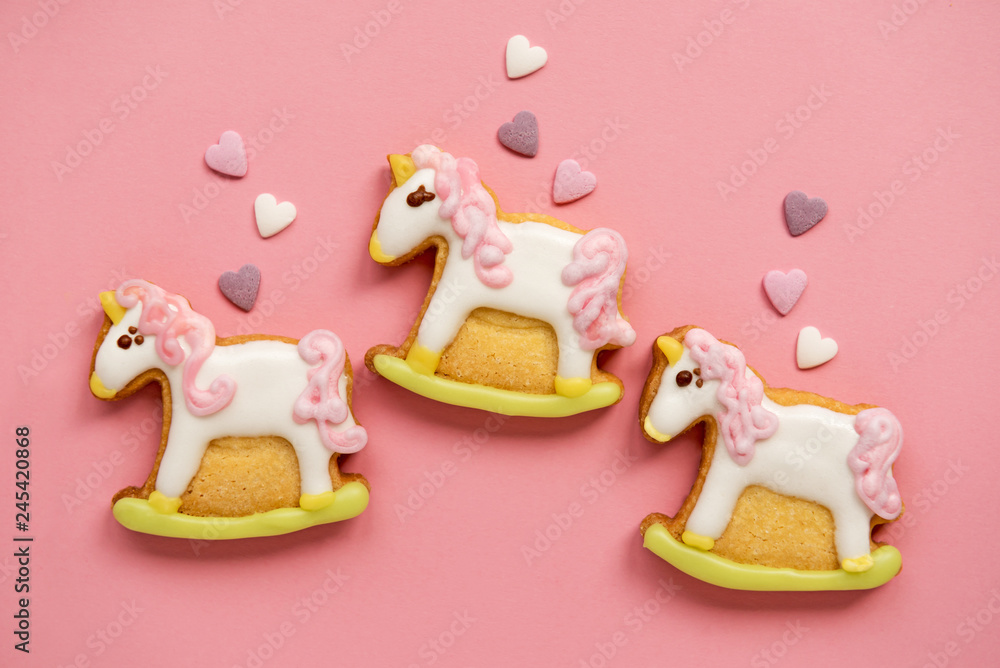 Naklejka premium Unicorn shaped sugar cookies decorated with pastel royal icing on pink background