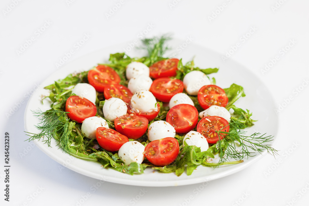Greek salad on the plate, mozzarella cheese and cherry tomato, white background Greek salad on the plate, mozzarella cheese and cherry tomato, white background