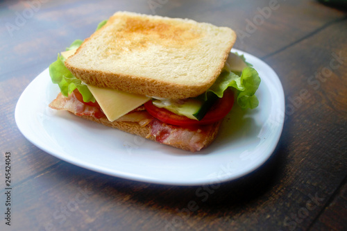 Sandwich with bacon, cheese and fresh vegetables