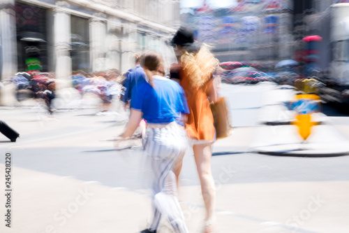 London, UK. Beautiful motion blur of two woman, walking in the Regent street in summer day. Busy life of the capital.