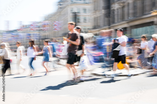 London, UK. Beautiful motion blur of young man, walking in the Regent street in summer day. Busy life of the capital.