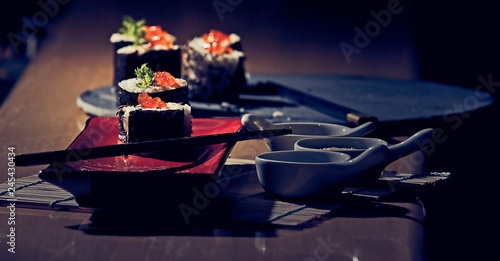 Sushi on a servery plate with accompaniment bowls photo