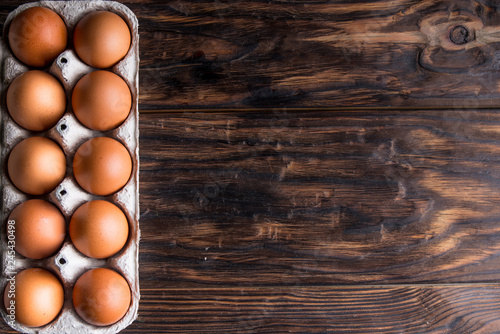 chicken eggs on old wooden board with blank space for text