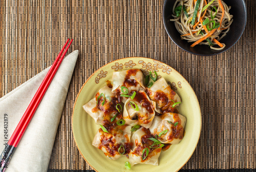 Chinese Dumplings on a plate with noodle salad