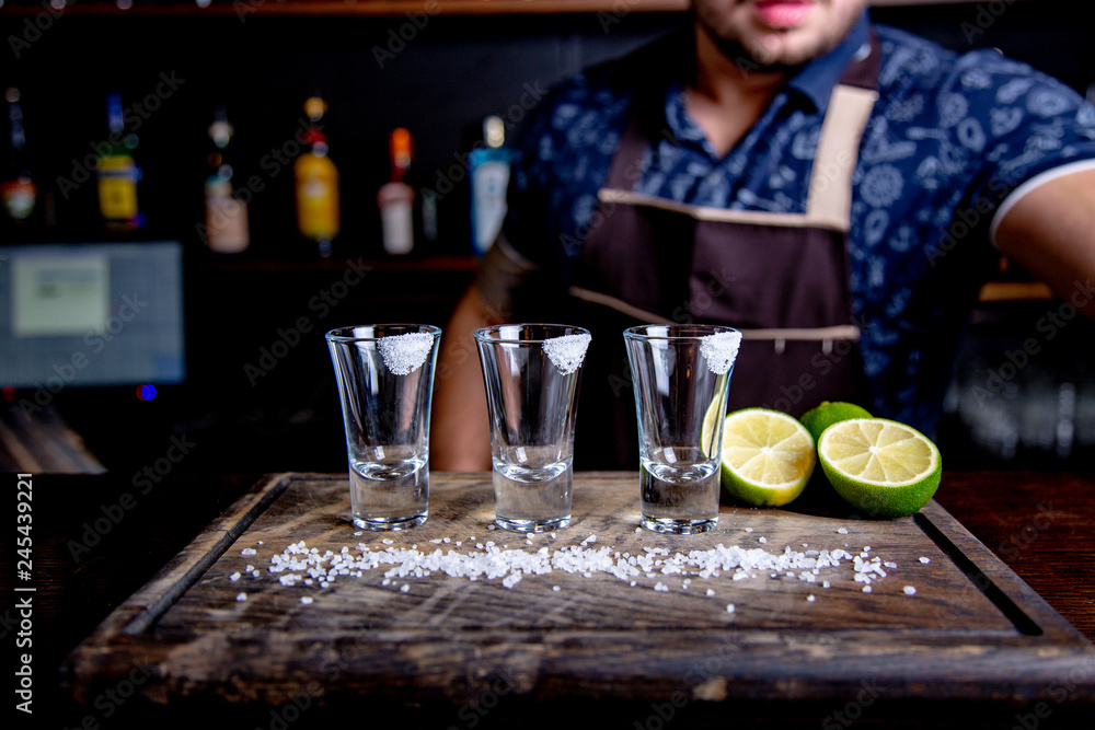 Tequila silver , alcohol in shot glasses, lime and salt, toned image, selective focus