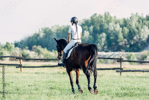 woman jockey riding a horse in summer