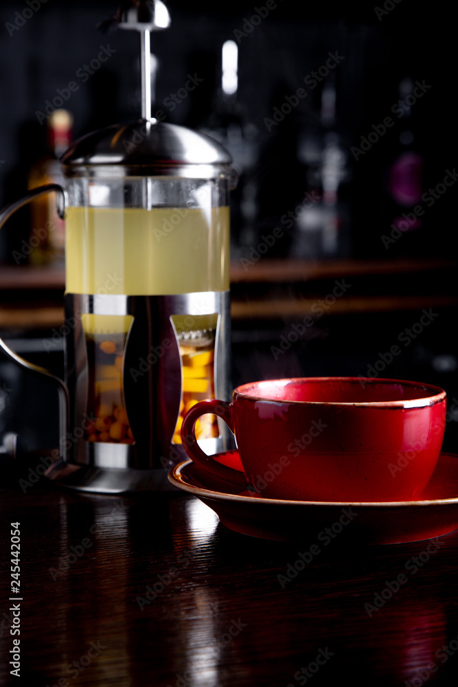 Sea buckthorn tea in french press on a bar background at coffee shop. Sea buckthorn tea in french press on a bar background at coffee shop.