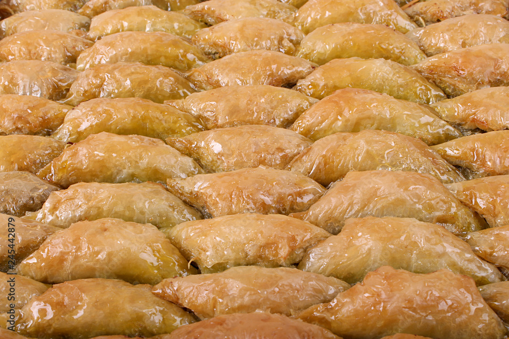 Baklava with a lot of green pistachios on the shabby table Baklava with a lot of green pistachios on the shabby table