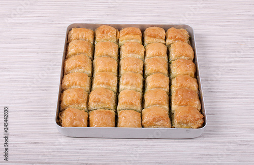 Baklava with green pistachios on white table