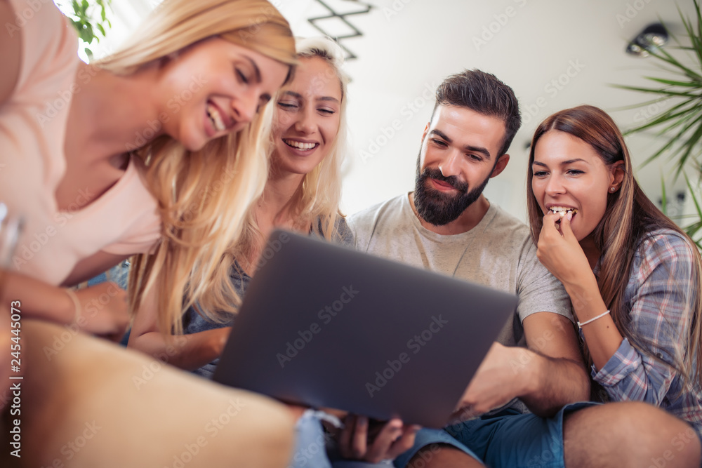Smiling friends looking at laptop together Smiling friends looking at laptop together