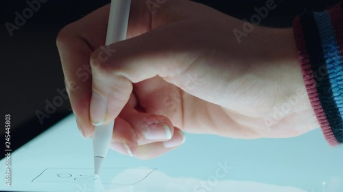 close up hand using digital tablet drawing with stylus pen graphic designer sketching planning layout on mobile touchscreen device photo