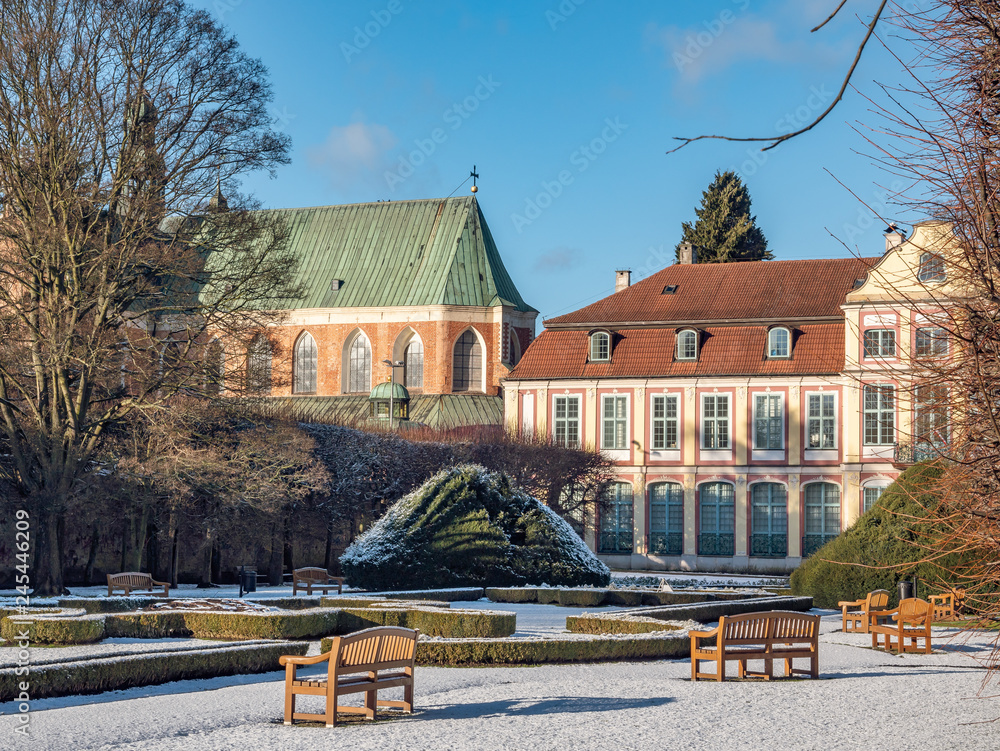 Abbots Palace built in the rococo style and located in Oliwa park with cathedral church in the back. Winter scenery. Gdansk, Poland
