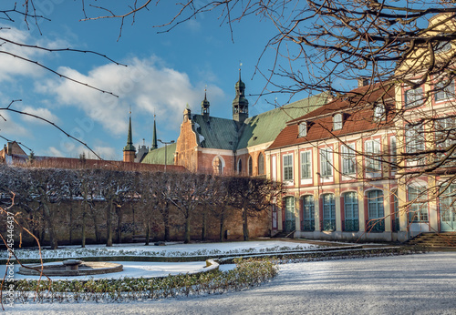 Abbots Palace built in the rococo style and located in Oliwa park with cathedral church in the back. Winter scenery. Gdansk, Poland photo