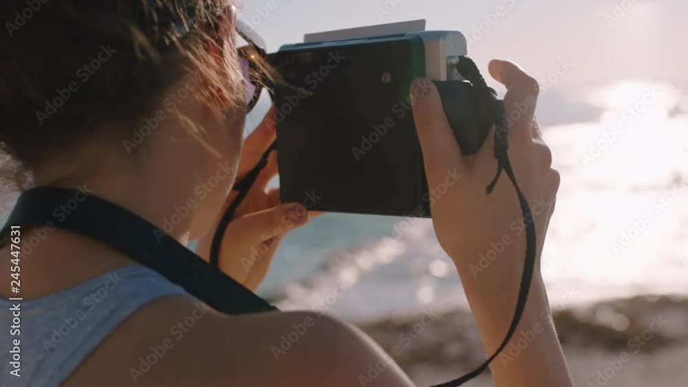 young woman photographer taking photos on beach using retro camera enjoying summer vacation day young girl photographing beautiful seaside