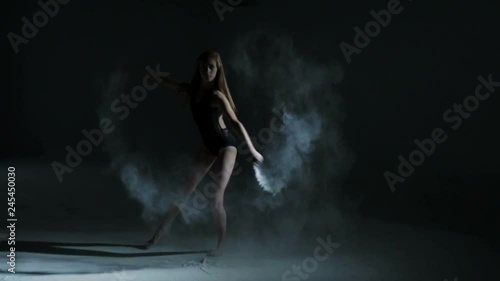 Teenage Caucasian girl in black leotard using powder in freestyle dancing
