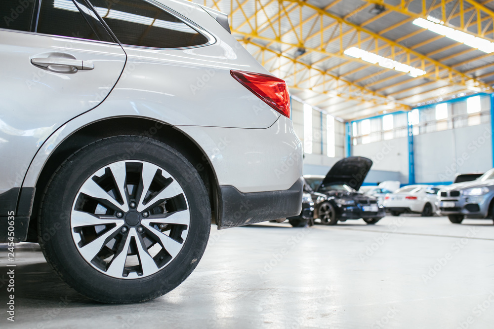 Modern Cars in repair maintenance auto service garage. Modern Cars in repair maintenance auto service garage.