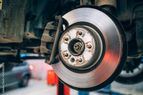 Close up of car disc brake during the wheel tire change or repair. Disc brake of the car during the maintenance at auto service garage.  © Hakan Tanak