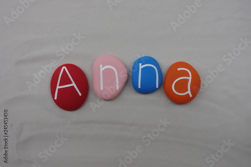 Anna, feminine given name composed with colored stones over white sand