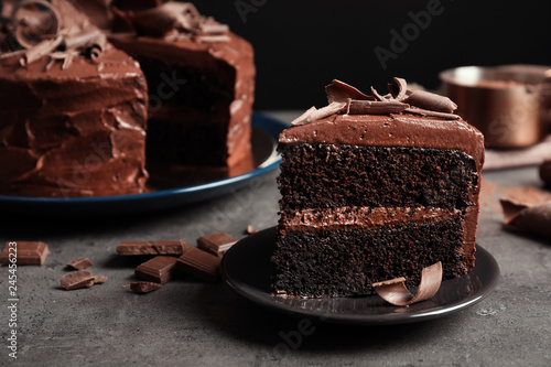 Stampa su tela Plate with slice of tasty homemade chocolate cake on table