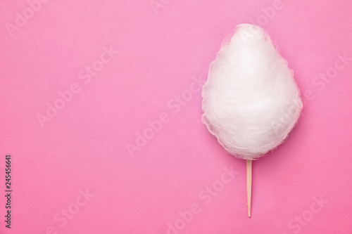 Stick with yummy cotton candy on color background, top view. Space for text