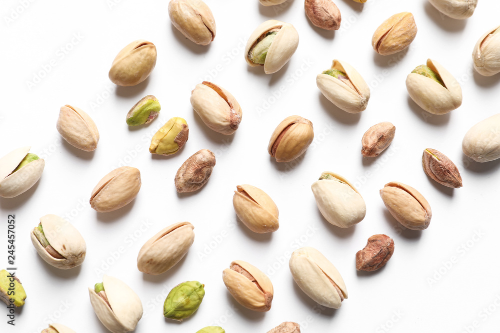 Composition with organic pistachio nuts on white background, top view
