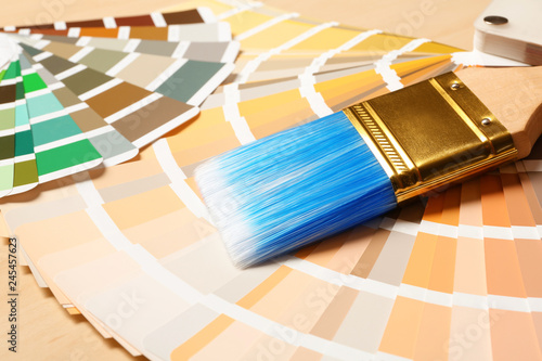Paint brush and color palettes on table, closeup