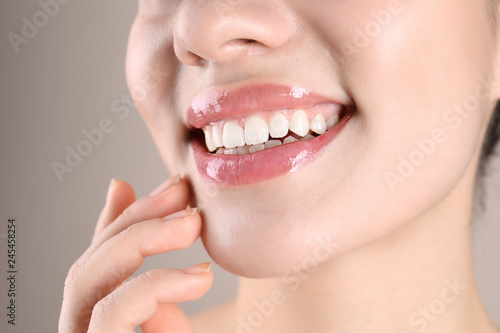 Fototapeta Naklejka Na Ścianę i Meble -  Beautiful young woman with healthy teeth on color background, closeup