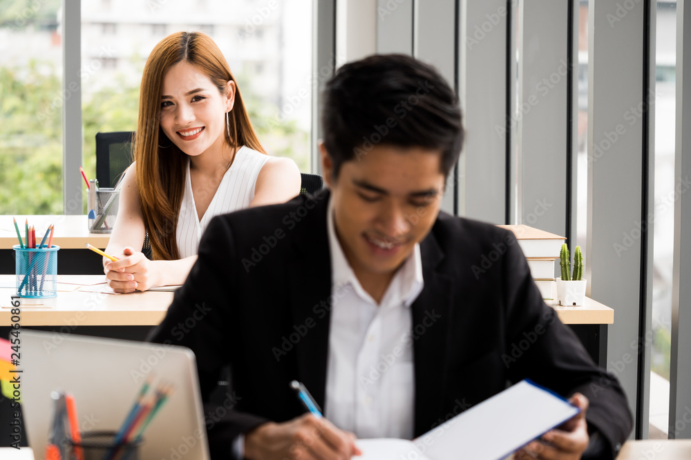 Beautiful Businesswoman is looking at Businessman at the office. Beautiful Businesswoman is looking at Businessman at the office.