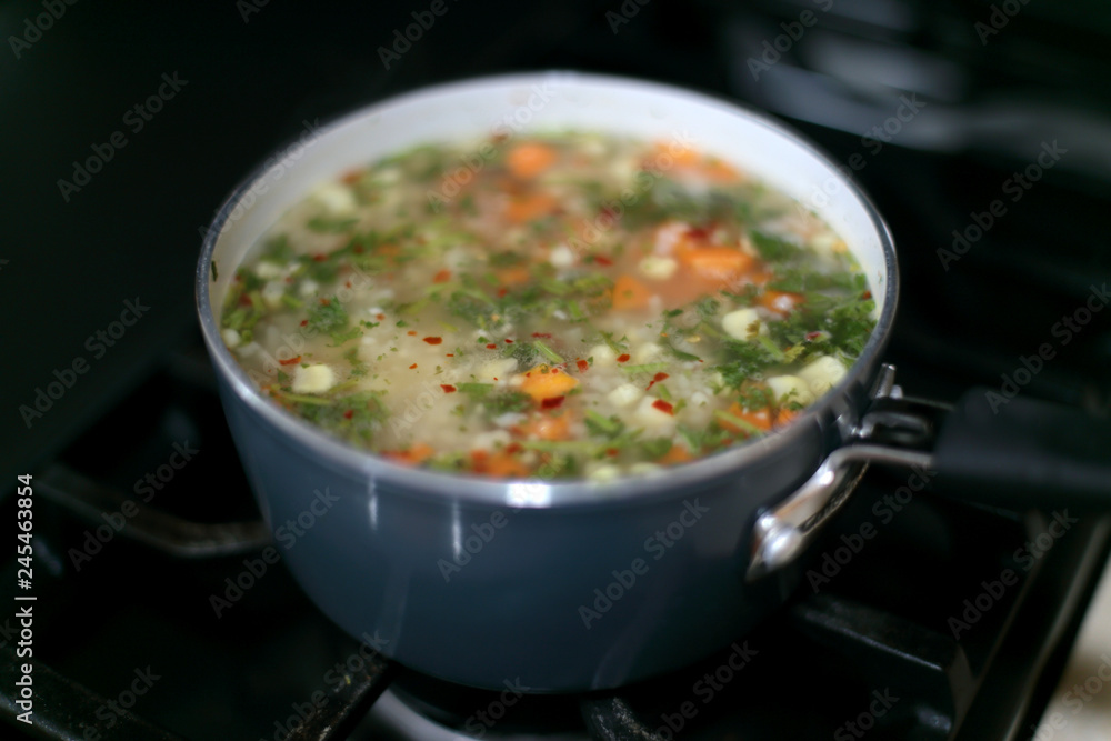 Pot of vegetable soup cooking on the stove. Pot of vegetable soup cooking on the stove.
