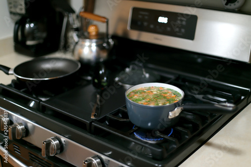 Pot of vegetable soup cooking on the stove.