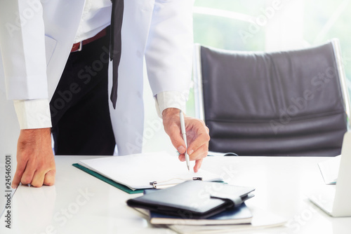 Young man doctor working at office desk in hospital. Medical and healthcare concept. photo