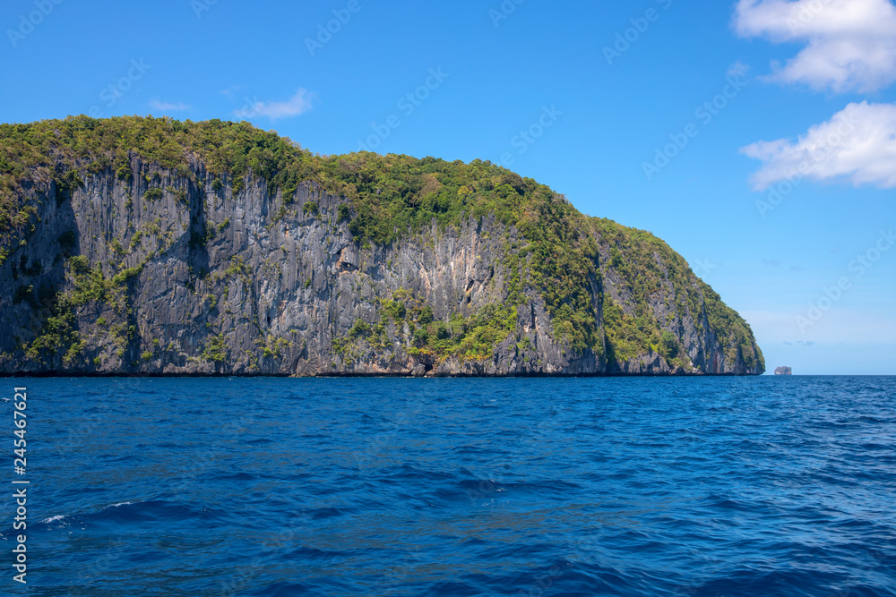 Tropical island in still sea. Palawan island seascape. Philippines travel photo. Black rock mountain with wild green forest