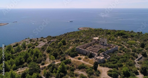 Mediterranean coast, C4k aerial, orbit, drone shot, on the top of a hill, overlooking of small croatian islands and a ferry, on the adriatic sea, on a sunny, summer day, in Croatia