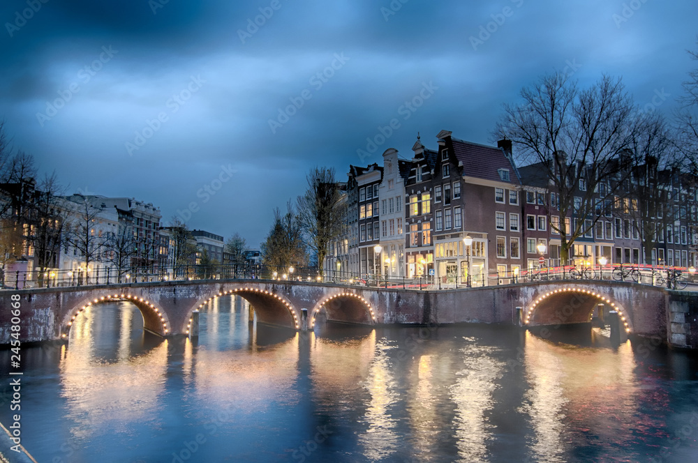 Fototapeta premium Keizersgracht inersection bridge view of Amsterdam canal and historical houses during twilight time, Netherland.