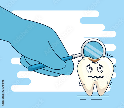 tooth with caries and mouth mirror in the dentist hand