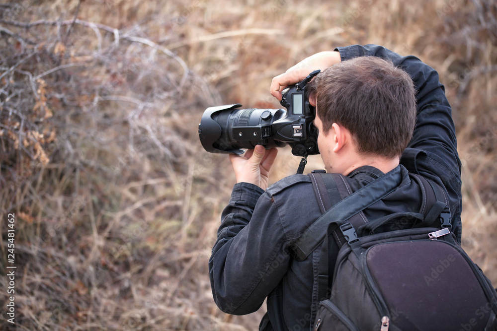 man with a camera on the nature takes something man with a camera on the nature takes something