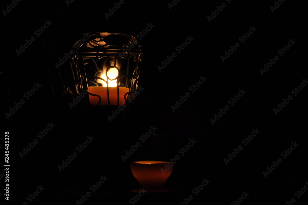 Lamp, candle shining in the darkness. Challis flame. Artistic composition. Lighting.